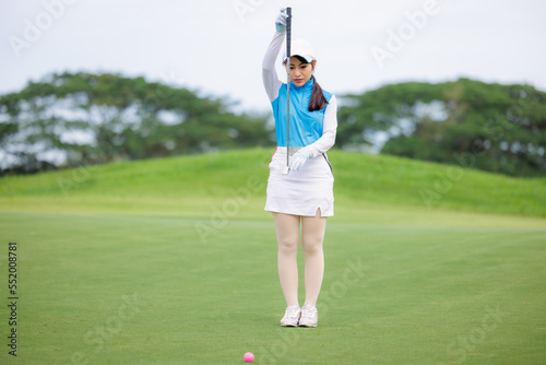 golfer asian women standing hold golf club checking fairway and teeing golf in golf tournament competition at golf course, . © SHUTTER DIN