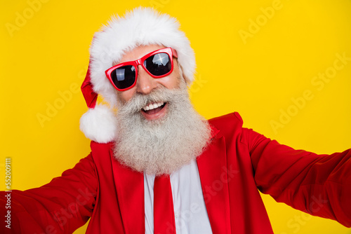 Photo of charming positive claus wear red tux costume tux smiling tacking video isolated yellow color background