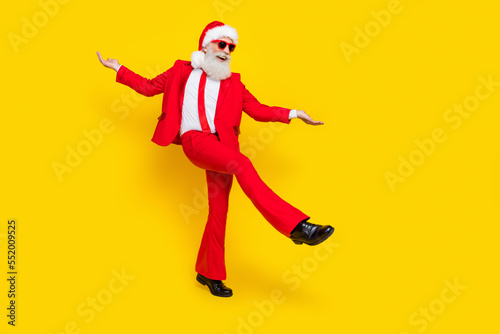 Full length photo of good mood retired guy wear red tux claus hat dancing empty space isolated yellow color background © deagreez