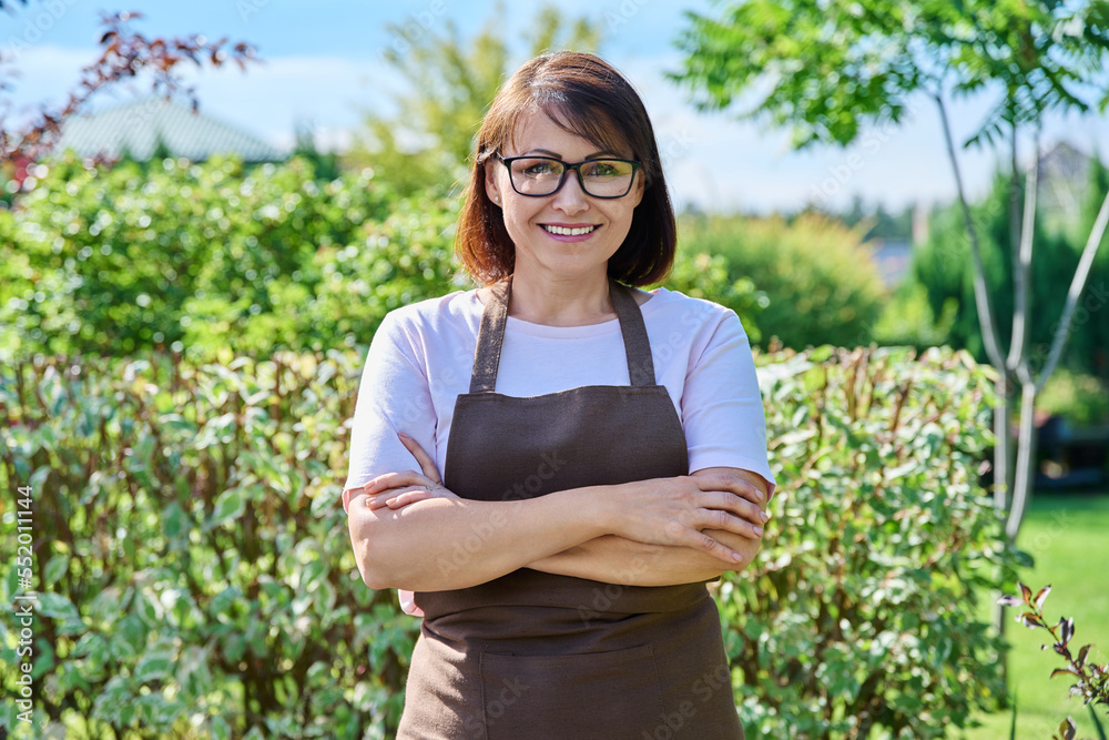 Outdoor portrait smiling female gardener looking at camera in backyard Outdoor portrait smiling female gardener looking at camera in backyard