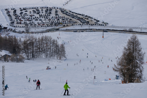 People sking snowboarding down the slope. Town of Livigno in winter. Livigno landscapes in Lombardy, Italy, located in the Italian Alps, near the Swiss border. photo