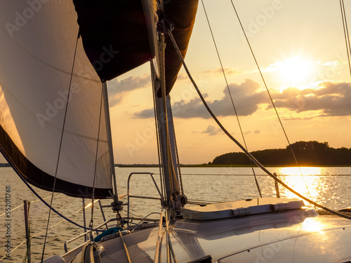 Fototapeta Naklejka Na Ścianę i Meble -  sailing yacht bow in sunset light, sailing on a lake