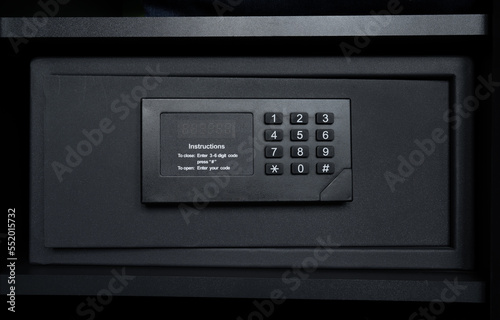 Black steel safe box with electronic security lock. Modern safety locker in a hotel room or at home.
