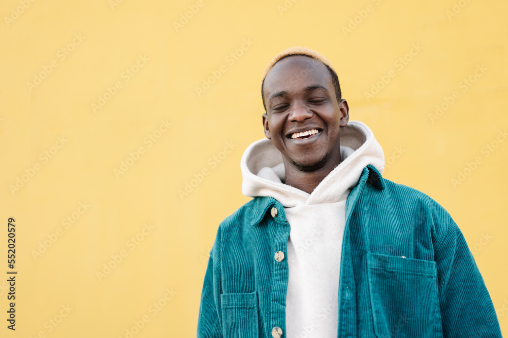 Funny African American Positive Young Man with closed eyes, smiling over yellow background. Portrait Human Expression Funny African American Positive Young Man with closed eyes, smiling over yellow background. Portrait Human Expression
