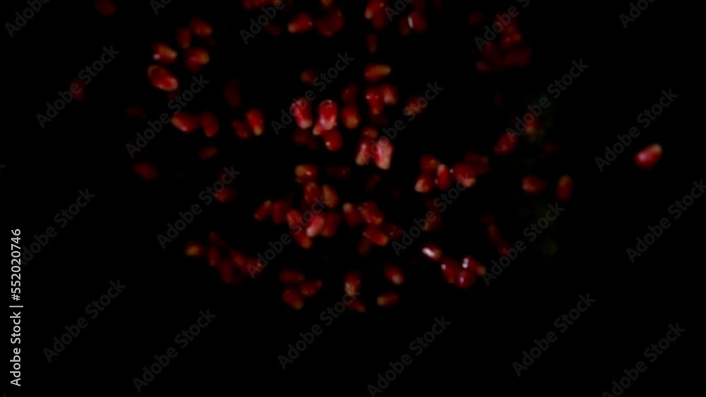 Pomegranate grains are bouncing up on the black background in slow motion Pomegranate grains are bouncing up on the black background in slow motion