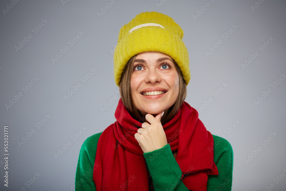 Smiling woman in casual warm clothes touching her chin and looking up. Advertising female studio portrait. Smiling woman in casual warm clothes touching her chin and looking up. Advertising female studio portrait.