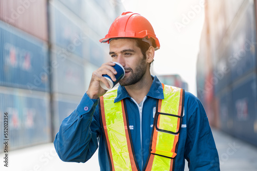 Male container yard worker break and drinking water at container terminal yard