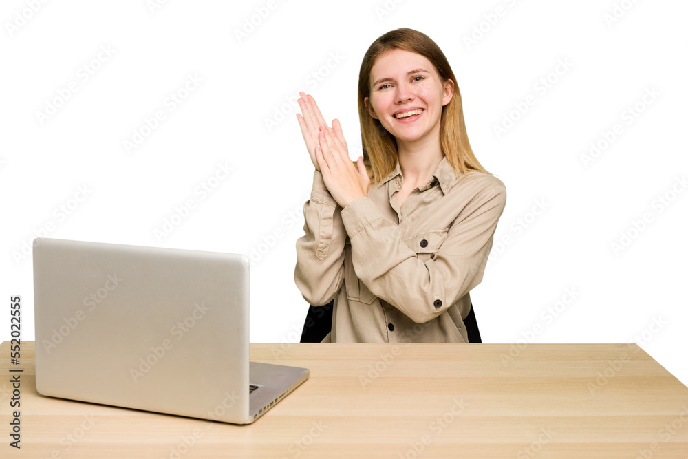 Young caucasian woman in a workplace working with a laptop isolated feeling energetic and comfortable, rubbing hands confident. Young caucasian woman in a workplace working with a laptop isolated feeling energetic and comfortable, rubbing hands confident.