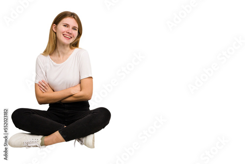 Young caucasian woman sitting on the floor cutout isolated