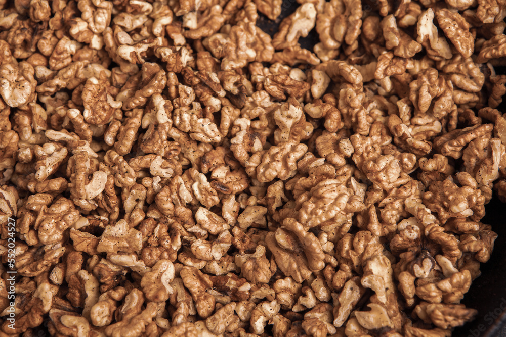 Walnut background. Peeled walnuts on a iron plate on black. walnuts a real super food full of vitamins and vegetable fats