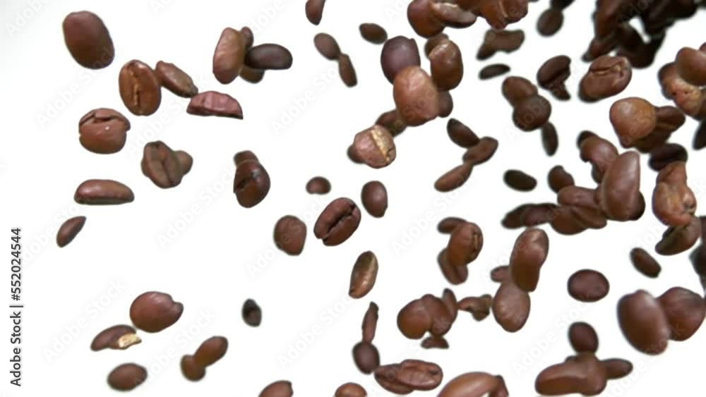 Close-up of the roasted Arabica coffee beans falling down on a white background Close-up of the roasted Arabica coffee beans falling down on a white background
