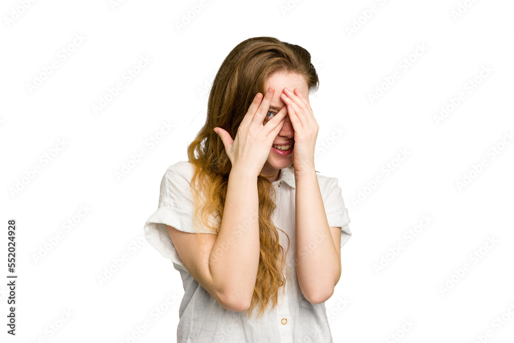 Young caucasian redhead woman isolated blink through fingers frightened and nervous. Young caucasian redhead woman isolated blink through fingers frightened and nervous.