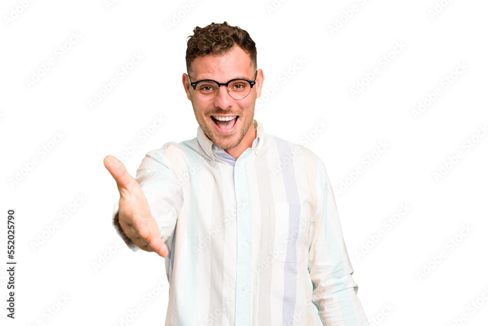 Young caucasian handsome man isolated stretching hand at camera in greeting gesture.
