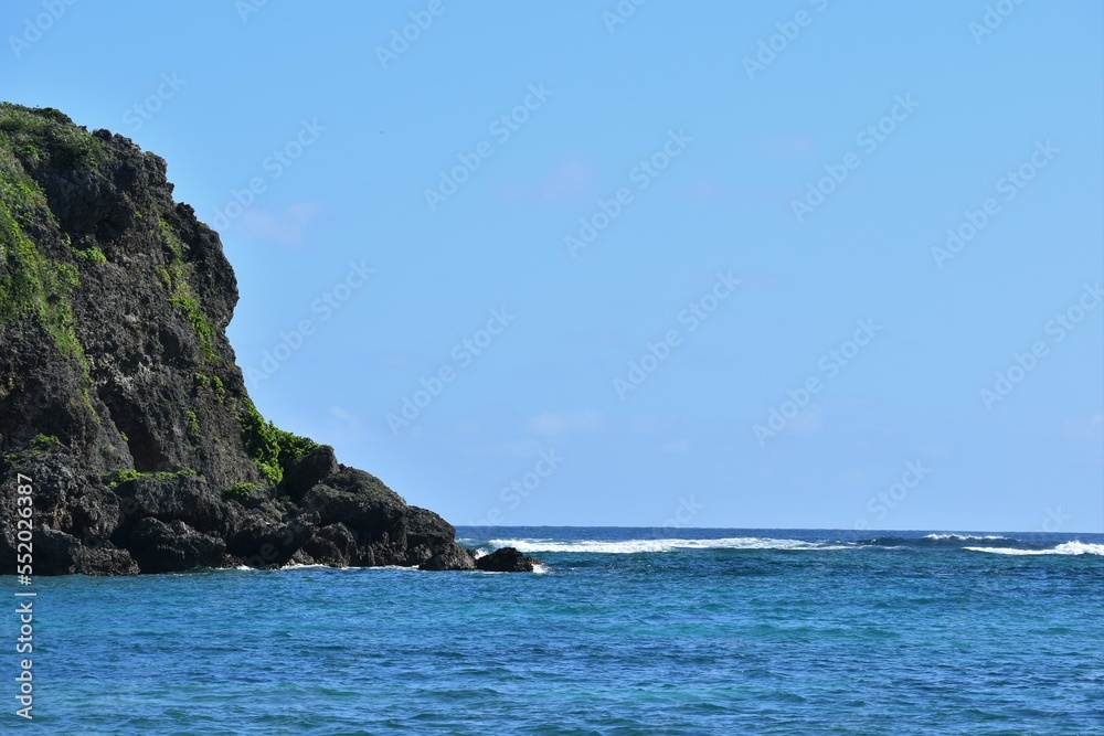 冬の沖縄の海岸の岩と青い海
