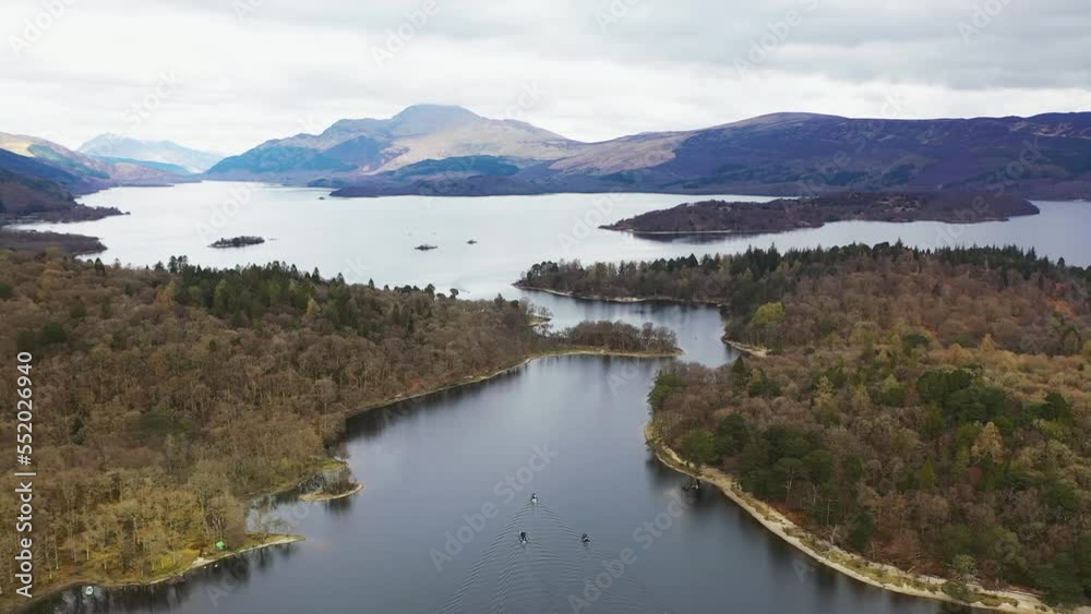 Aerial drone angle of boats travelling through the narrows on Loch Lomond, Scotland, with Luss and Ben Lomond in the background in early spring. Aerial drone angle of boats travelling through the narrows on Loch Lomond, Scotland, with Luss and Ben Lomond in the background in early spring.