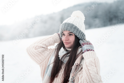  Portrait of a happy and beautiful brunette girl in the snow,young woman with winter hat and warm gloves in the sunny winter day,Outdoor waist up portrait,winter and christmas atmosphere,in winter 