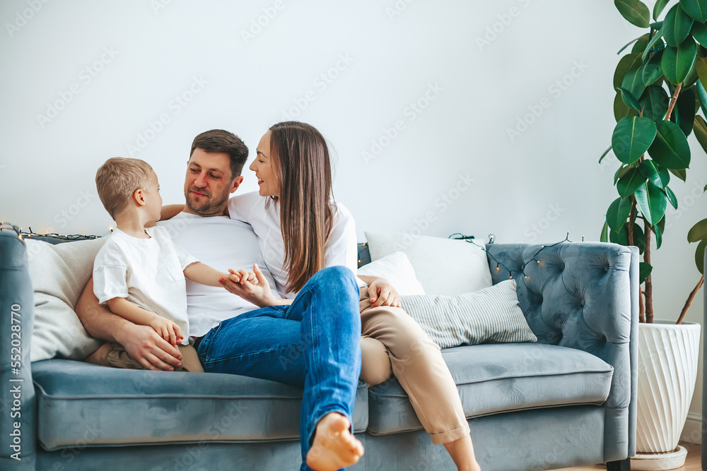 Happy young family with child sitting on a couch