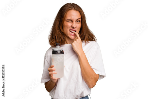 Young caucasian sport woman holding a bottle of water isolated relaxed thinking about something looking at a copy space.