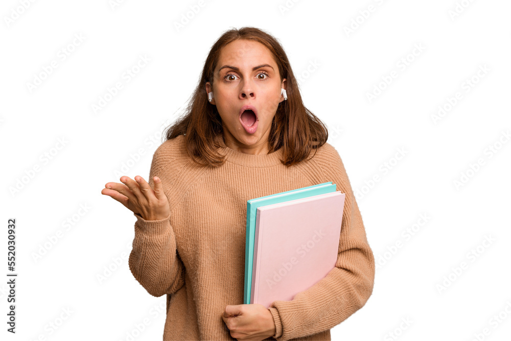 Young student woman holding a books isolated surprised and shocked. Young student woman holding a books isolated surprised and shocked.