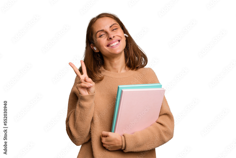 Young student woman holding a books isolated joyful and carefree showing a peace symbol with fingers. Young student woman holding a books isolated joyful and carefree showing a peace symbol with fingers.