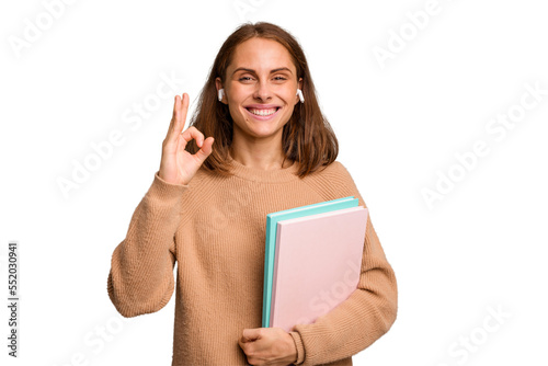 Young student woman holding a books isolated cheerful and confident showing ok gesture.