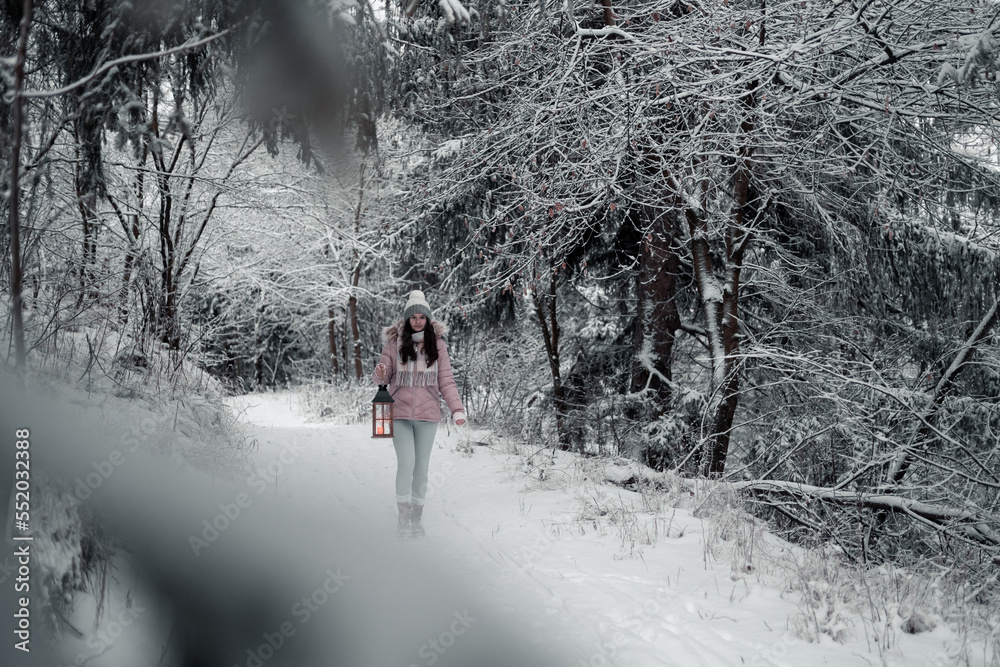 Portrait of a girl,woman with a lantern in her hand, a girl holding a Christmas light and looking at it, Christmas and frosty atmosphere, a scene in the middle of a snowy forest,warm clothes,snow