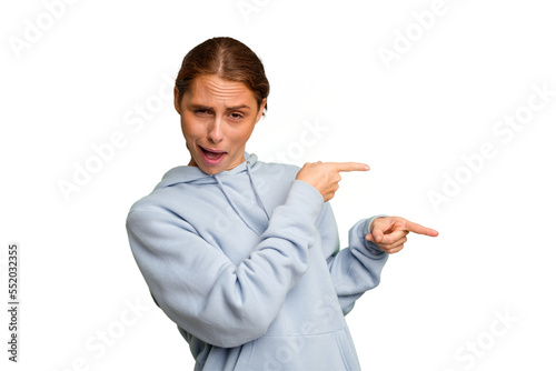 Young caucasian woman isolated pointing with forefingers to a copy space, expressing excitement and desire.