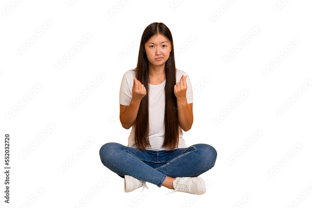 Young asian woman sitting on the floor cutout isolated showing that she has no money. Young asian woman sitting on the floor cutout isolated showing that she has no money.
