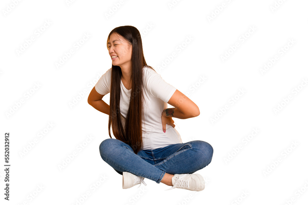 Young asian woman sitting on the floor cutout isolated suffering a back pain.