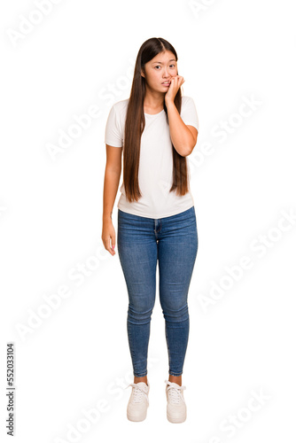 Young asian woman standing, full body cutout isolated biting fingernails, nervous and very anxious. © Asier