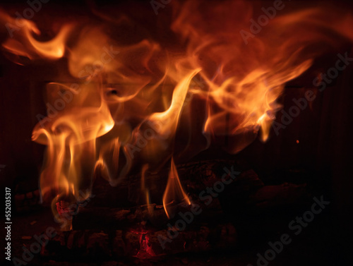 Fire flames and burning wood logs, fireplace close up, warm home in winter