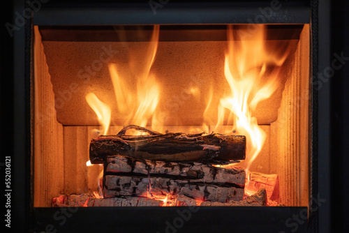 Fire flames and burning wood logs  energy stove fireplace close up 