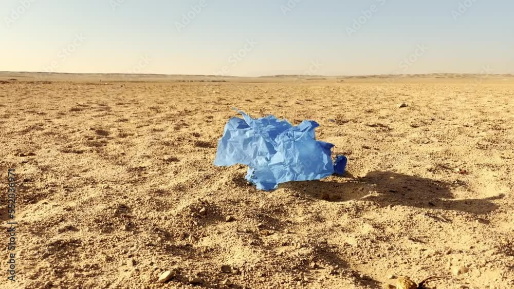 Blue piece of plastic tumbling in the desert Blue piece of plastic tumbling in the desert