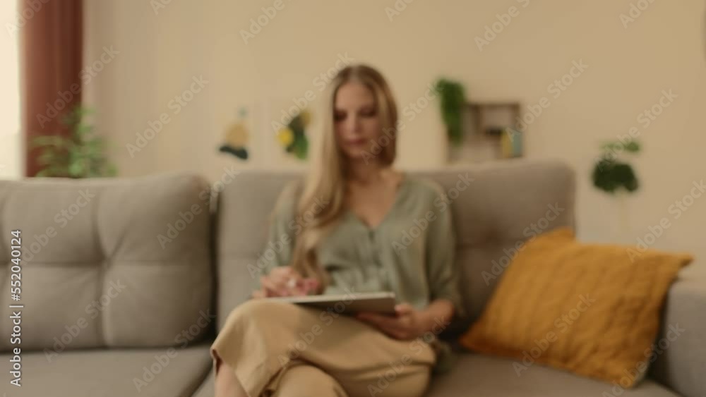 Happy young designer drawing on a graphics tablet with a stylus pen. Creative young freelancer working in her home office. Happy young designer drawing on a graphics tablet with a stylus pen. Creative young freelancer working in her home office.