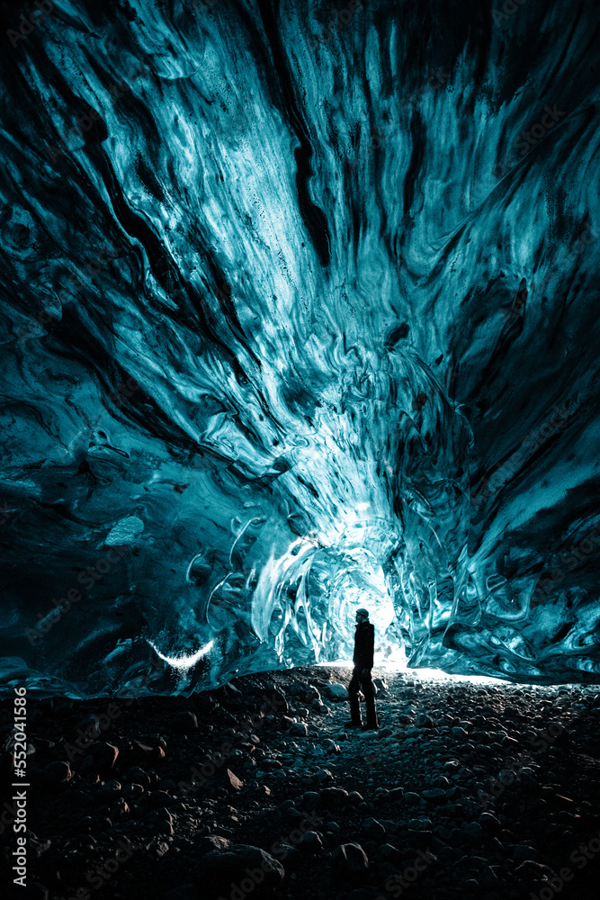 Fototapeta premium Person is standing in beautiful ice cave in Vatnajkull glacier Iceland in the winter