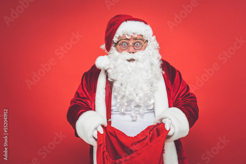 Funny crazy santa claus having fun on a red colored background