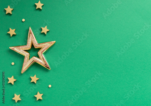 Golden stars on green. Christmas, new year 2023 concept. Top view of different christmas stars.Flat lay, top view.