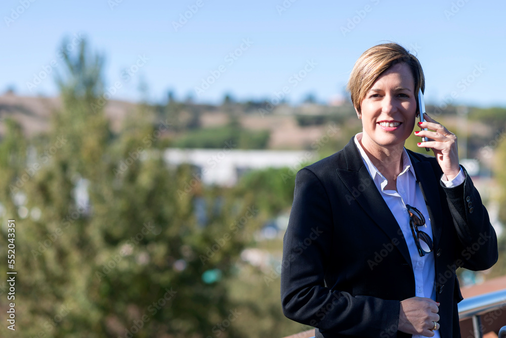 Happy businesswoman making a phone call during her morning commute in the city