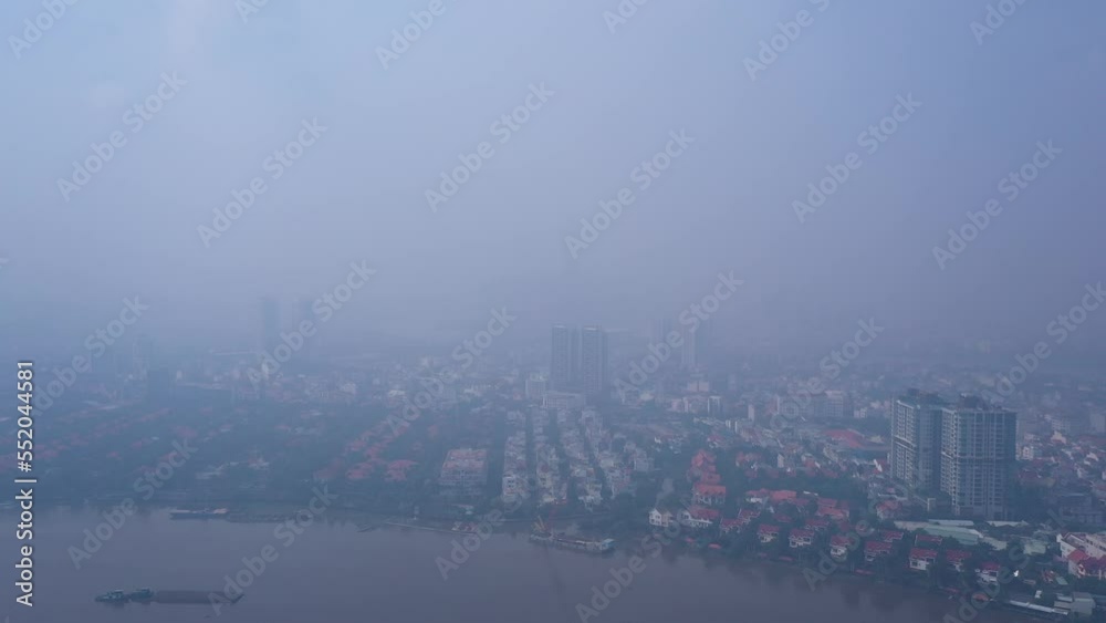 A sunny day with high air pollution flying in towards Ho Chi Minh City and Saigon river. City skyline is invisible. A sunny day with high air pollution flying in towards Ho Chi Minh City and Saigon river. City skyline is invisible.