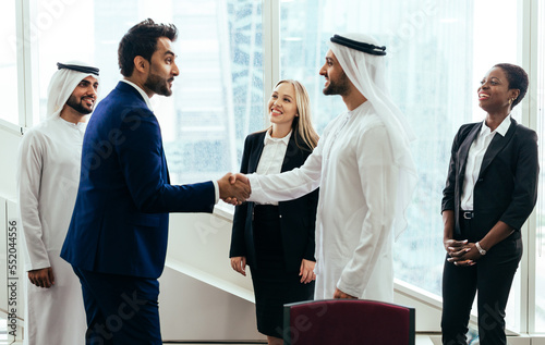 Multiethnic western and middle eastern business team working together in an office of Dubai. Sales people and employees at work on new projects