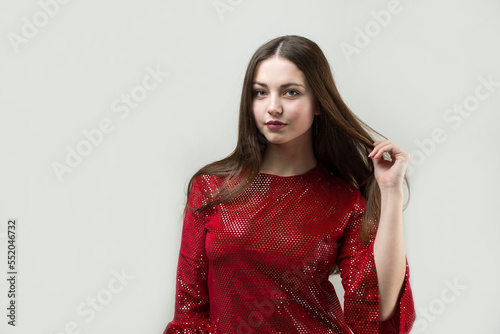 Portrait of a young brunette with long hair in the studio.