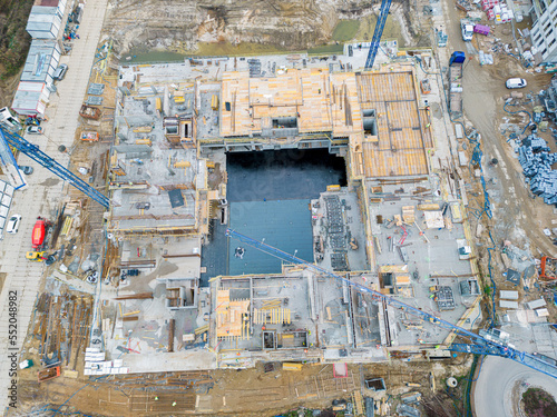 Aerial view of construction site with crane and building. Top view of big development construction and architecture. © netsay