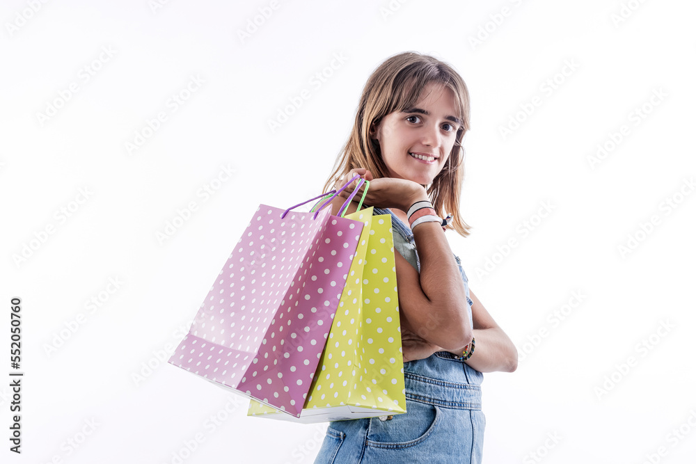 Photo portrait of cute young girl holding shopping bags isolated on blue color background