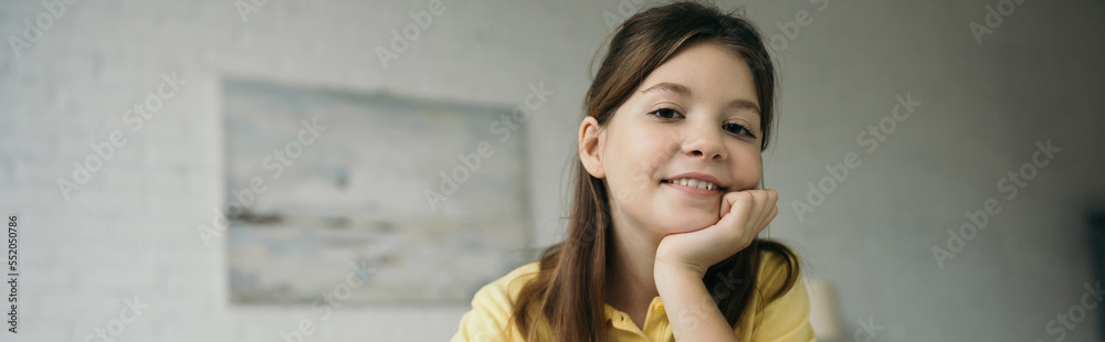 portrait of joyful preteen girl holding hand near face and looking at camera, banner portrait of joyful preteen girl holding hand near face and looking at camera, banner
