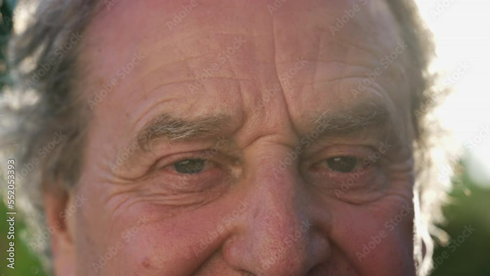 One happy senior man eyes macro close up. Portrait of a mature older male person in 70s smiling outdoors One happy senior man eyes macro close up. Portrait of a mature older male person in 70s smiling outdoors