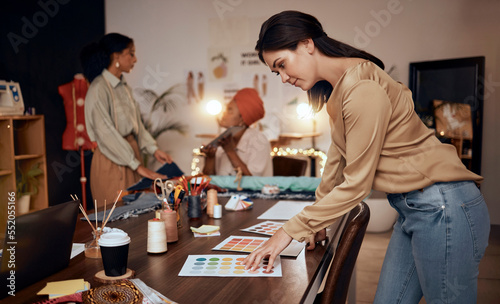 Fashion, workshop and manufacturing women at night for small business, startup production or retail management of color choice. Textile industry, clothes supplier and people at desk in team planning
