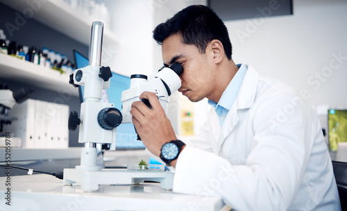Microbiology, research and scientist with microscope for bacteria in a lab, studying particles and science atom. Healthcare, innovation and worker with technology for medicine, atom data and test