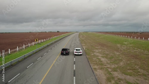 AERIAL - Two cars on empty highway, cloudy day, Reynosa, Tamaulipas, Mexico, forward photo