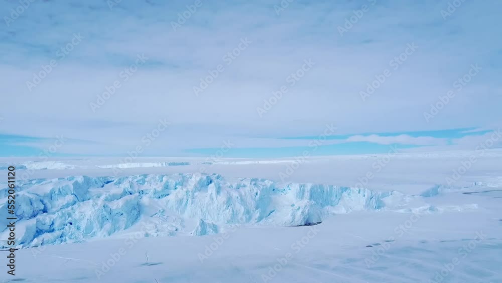 Snow covered antarctic surface aerial view flight. Desert white land of snow and ice drone shot. Frozen south pole. 