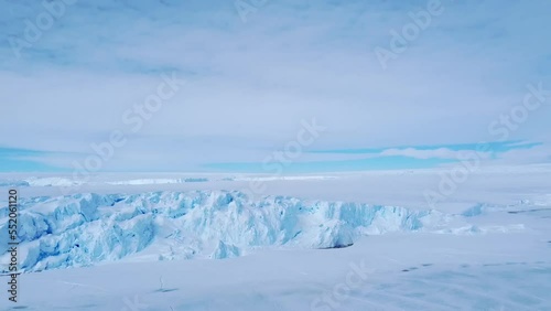 Snow covered antarctic surface aerial view flight. Desert white land of snow and ice drone shot. Frozen south pole. 